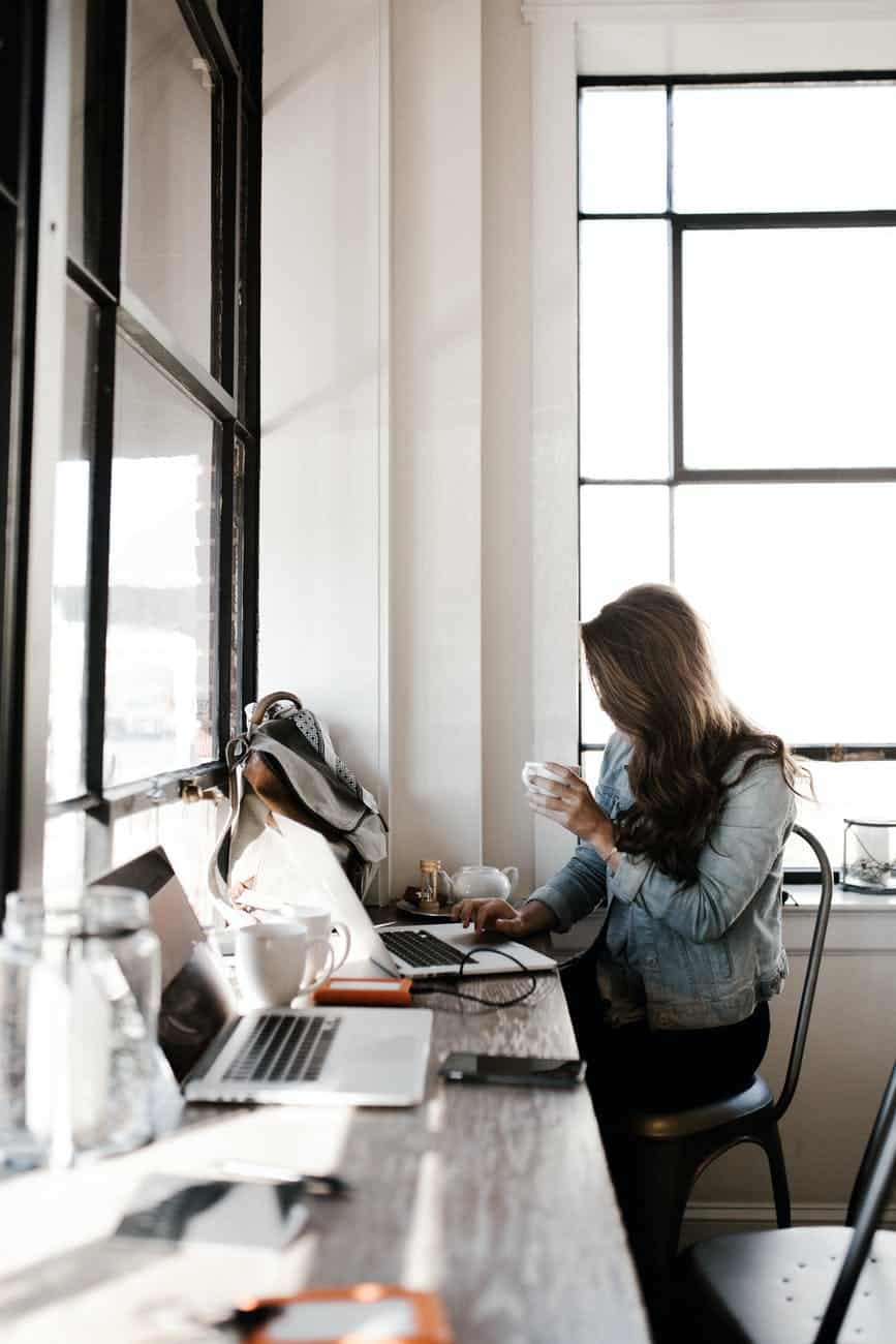 woman in gray jacket sitting beside desk