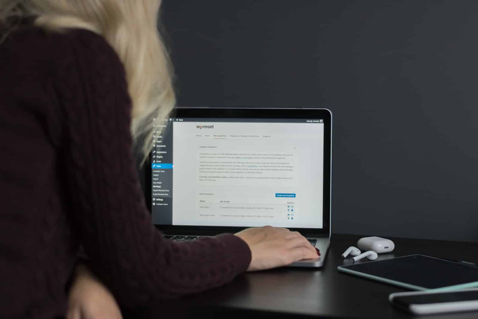 woman sitting at desk using macbook pro