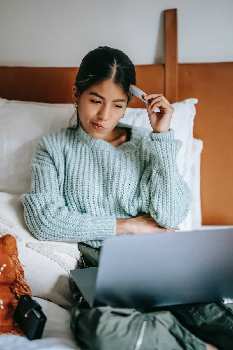 young lady looking at computer screen looking indecisive