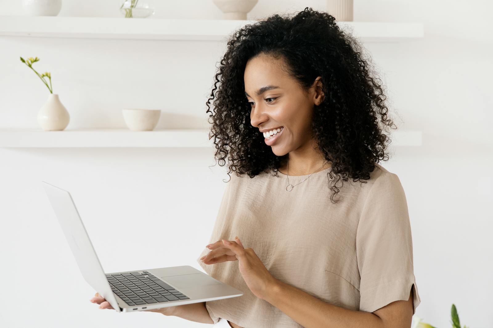 A Woman using a Laptop updating old posts makes her happy